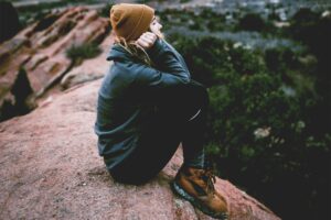 Woman sitting on top of a rock mountain
