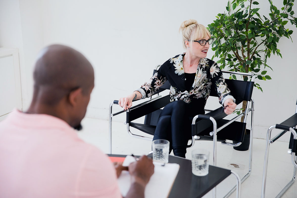 A therapist provides one-on-one psycho-education as a client takes notes, a collaborative approach to learning new coping strategies and skills for long-term recovery.