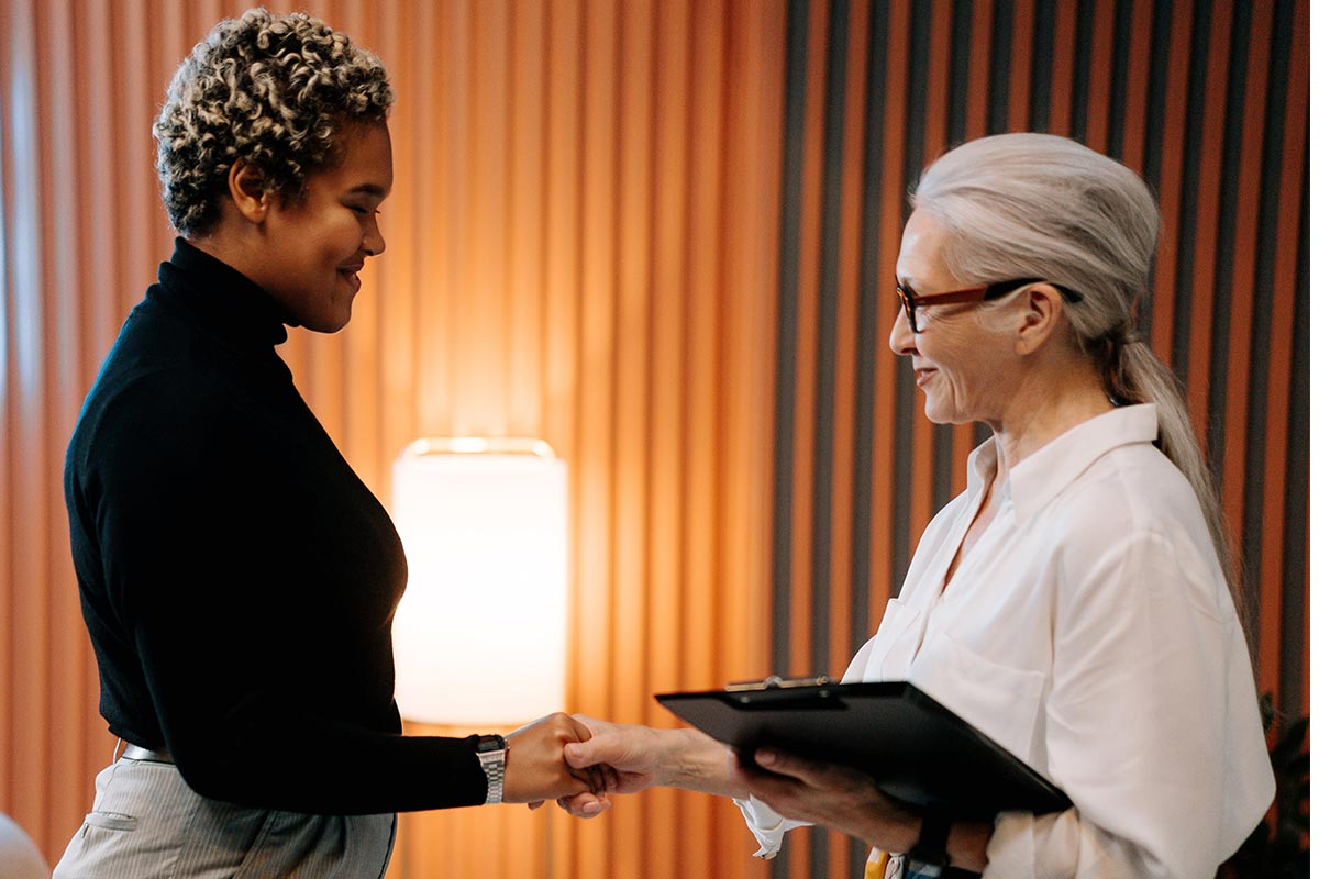 An experienced therapist welcomes a new client with a handshake, establishing a foundation of trust and respect for their therapy sessions.