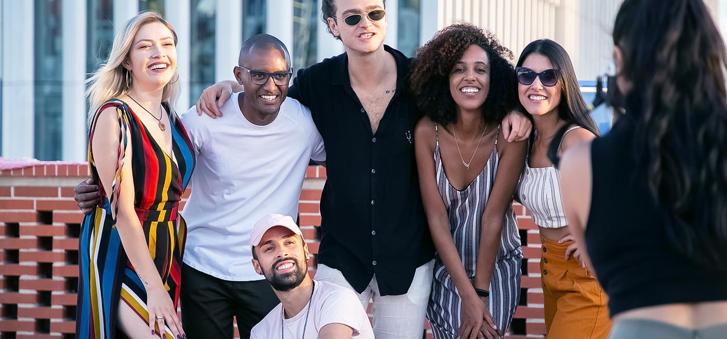 A diverse group of friends from a support group pose happily for a photo, illustrating the vibrant social connections and strong community that are essential for long-term mental health and recovery.